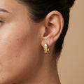 Boucles d'oreilles mini créoles pyramides en or jaune 18k serties - bijou porté par une mannequin