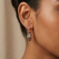 Boucles d'oreilles pendantes serpents en or rose 18k émaillées noir serties - bijou porté par une mannequin