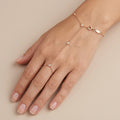 Bracelet-bague en or rose 18k chaîne d'annulaire, pierres en station - bijou porté par une mannequin