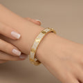 Bracelet jonc vis en or jaune 18k pavé de pierres - bijou porté par une mannequin