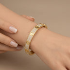 Bracelet jonc vis en or jaune 18k pavé de pierres - bijou porté par une mannequin