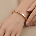 Bracelet jonc vis en or rose 18k - bijou porté par une mannequin