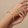 Bracelet jonc en or rose 18k motif zigzag - bijou porté par une mannequin