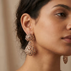 Boucles d'oreilles pendantes beldi rosaces et gouttes ajourées en or rose 18k serties - bijou porté par une mannequin