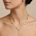 Collier en or rose 18k fleurs serties de pierres en station - bijou porté par une mannequin