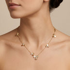 Collier en or rose 18k fleurs serties de pierres en station - bijou porté par une mannequin