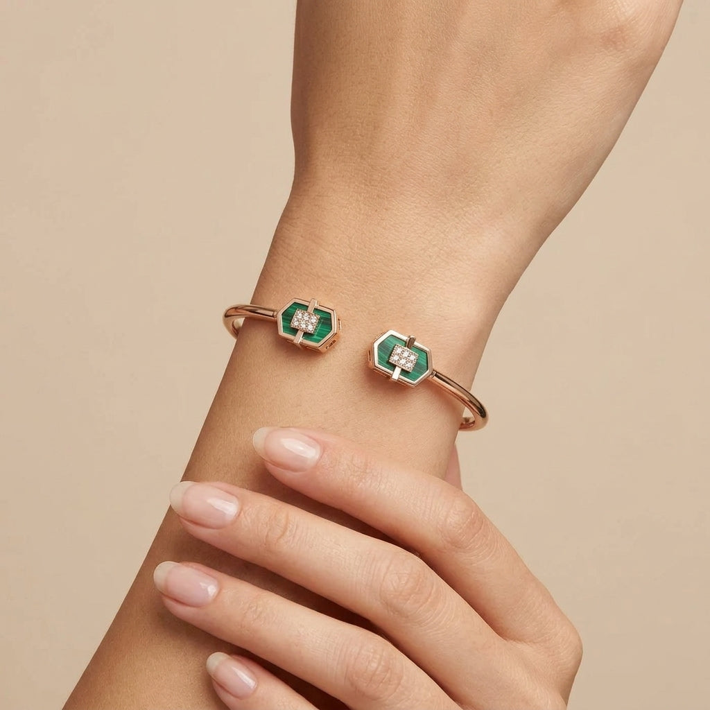 Bracelet jonc ouvert en or rose 18k pierres vertes rectangulaires serties - bijou porté par une mannequin