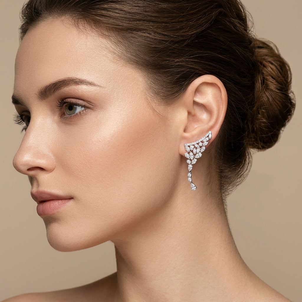 Boucles d'oreilles pendantes en or blanc 18k pavées de pierres - bijou porté par une mannequin