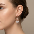 Boucles d'oreilles pendantes croissants en or rose 18k pavés de pierres - bijou porté par une mannequin