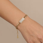 Gourmette maille cubaine en or jaune 18k plaque sertie de pierres baguettes - bijou porté par une mannequin