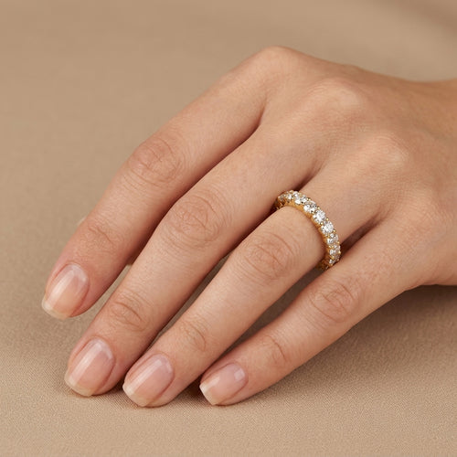 Bague alliance tour complet en or jaune 18k sertie de pierres - bijou porté par une mannequin