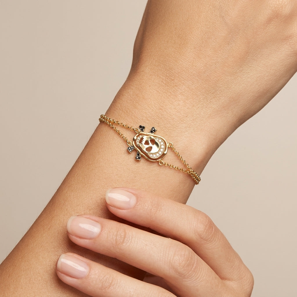 Bracelet chaîne en or jaune 18k tête de mort sertie de pierres - bijou porté par une mannequin