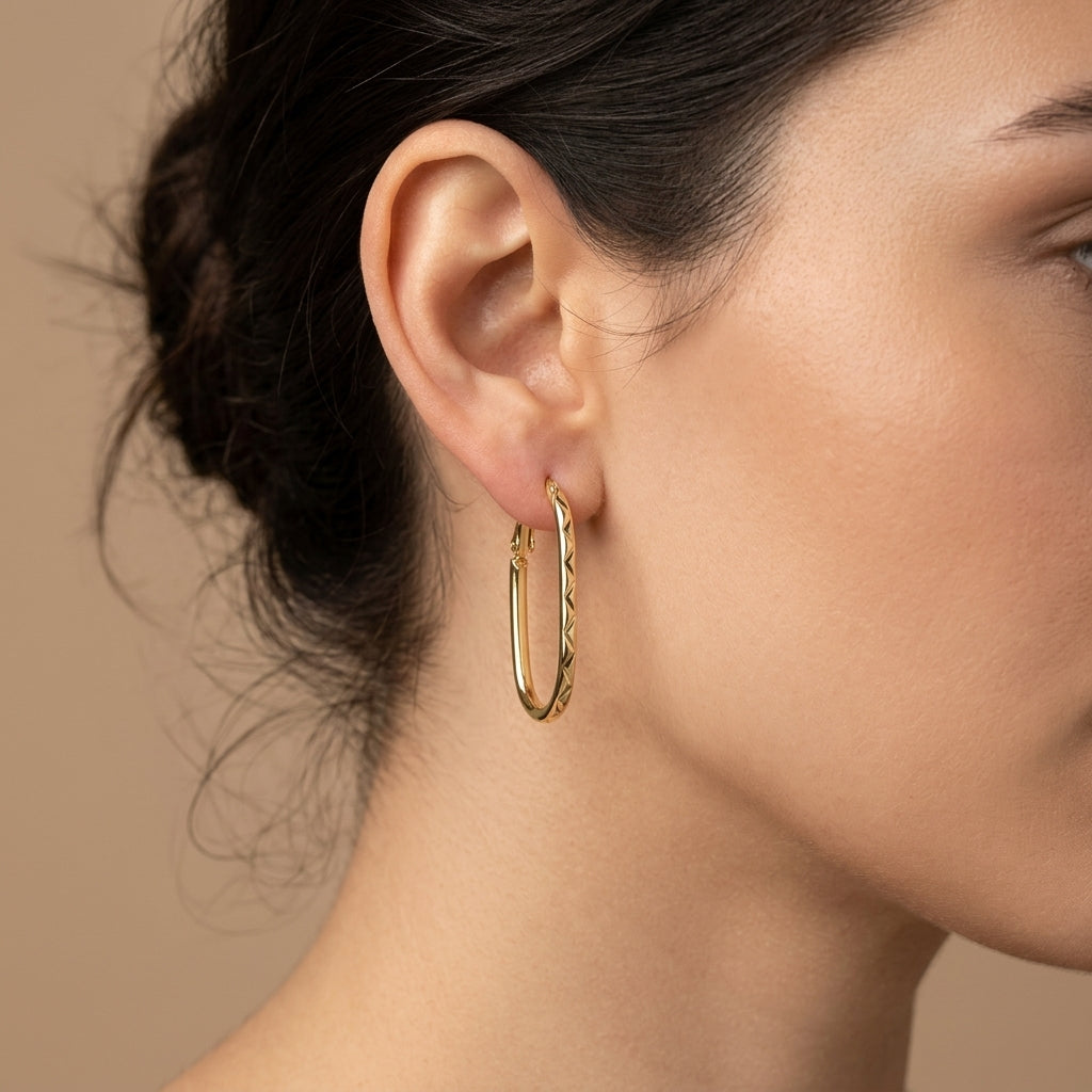Boucles d'oreilles créoles ovales en or jaune 18k - bijou porté par une mannequin