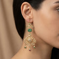 Boucles d'oreilles pendantes beldi rosaces ajourées en or jaune 18k pierres vertes, pampilles - bijou porté par une mannequin