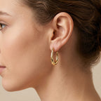 Boucles d'oreilles créoles ovales bombées en or rose 18k - bijou porté par une mannequin