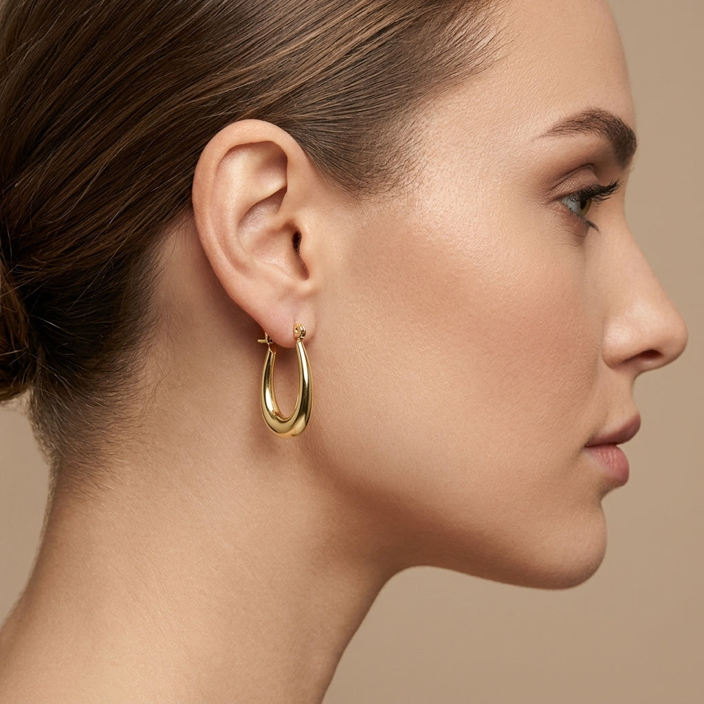 Boucles d'oreilles créoles ovales bombées en or jaune 18k - bijou porté par une mannequin