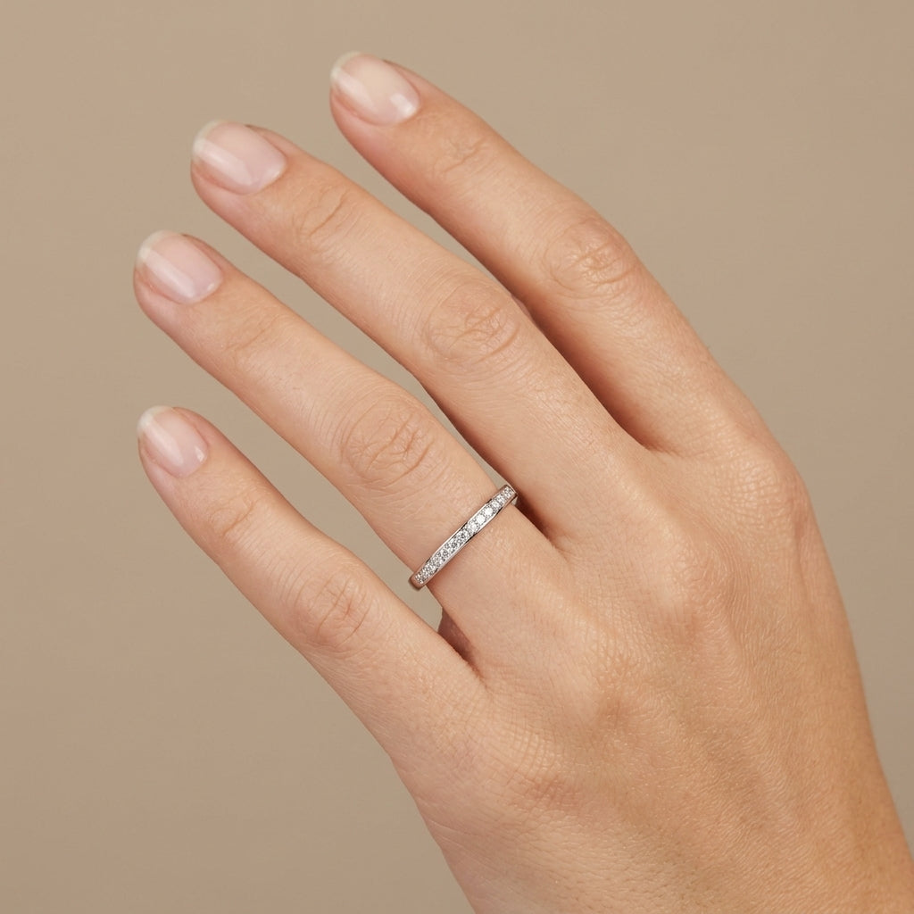 Bague demi-alliance fine en or blanc 18k sertie de pierres - bijou porté par une mannequin
