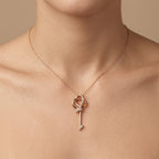 Pendentif clé nœud en or rose 18k sertie de pierres - bijou porté par une mannequin