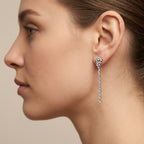 Boucles d'oreilles pendantes en or blanc 18k rangées de pierres serties - bijou porté par une mannequin