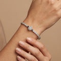 Bracelet jonc en or blanc 18k serti de pierres, poire centrale - bijou porté par une mannequin