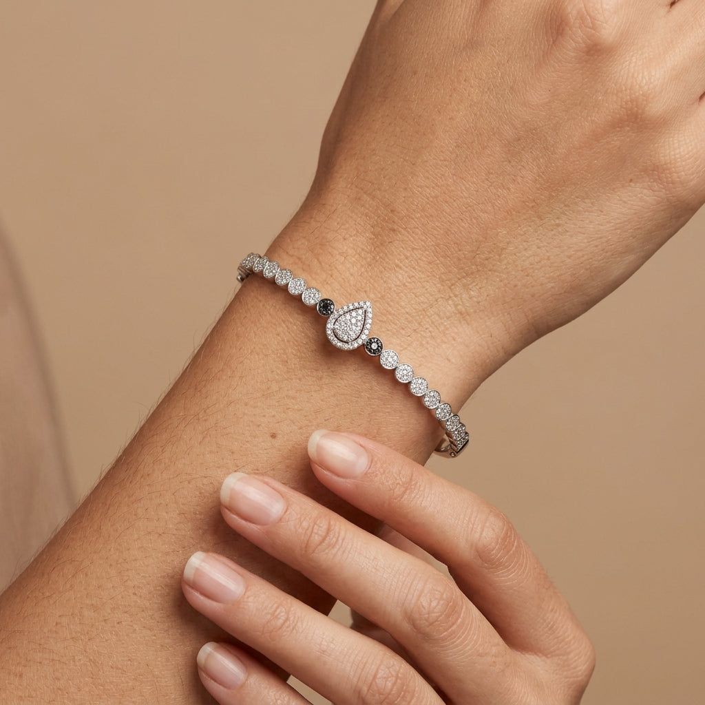 Bracelet jonc en or blanc 18k serti de pierres, poire centrale - bijou porté par une mannequin