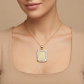 Pendentif plaque rectangulaire en or jaune 18k gravée d'une sourate, entourage serti - bijou porté par une mannequin