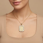Pendentif plaque rectangulaire en or jaune 18k gravée d'une sourate, entourage serti - bijou porté par une mannequin