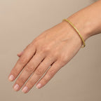 Bracelet jonc fin en or jaune 18k rangée de pierres jaunes serties - bijou porté par une mannequin