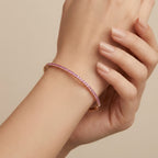 Bracelet jonc fin en or rose 18k rangée de pierres roses serties - bijou porté par une mannequin