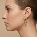 Boucles d'oreilles créoles ovales lisses en or jaune 18k - bijou porté par une mannequin