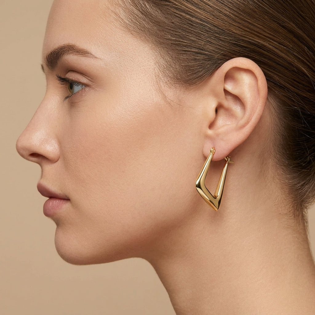 Boucles d'oreilles créoles ovales lisses en or jaune 18k - bijou porté par une mannequin