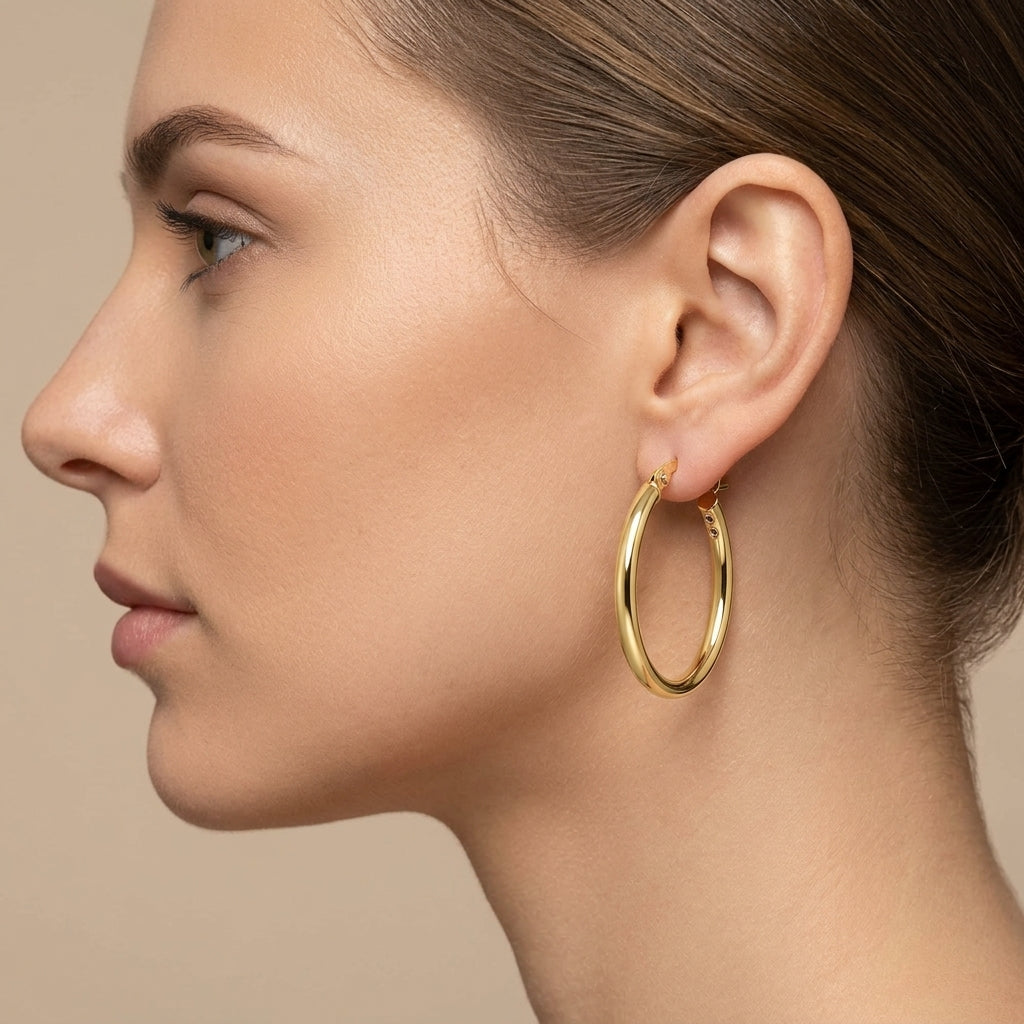 Boucles d'oreilles créoles ovales fines en or jaune 18k - bijou porté par une mannequin