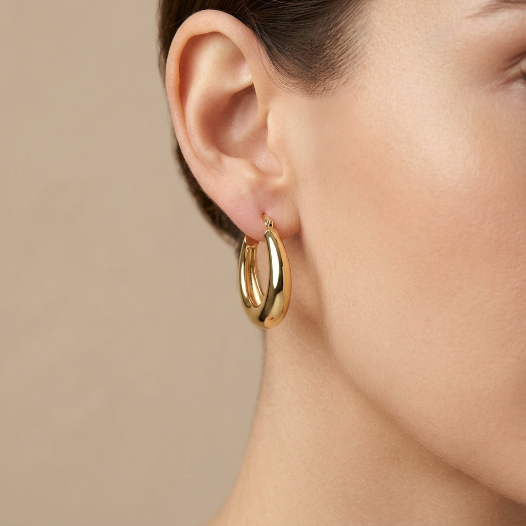 Boucles d'oreilles créoles bombées lisses en or jaune 18k - bijou porté par une mannequin