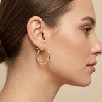 Boucles d'oreilles créoles en or jaune 18k - bijou porté par une mannequin