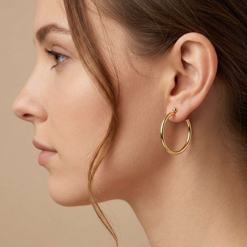 Boucles d'oreilles créoles fines en or jaune 18k - bijou porté par une mannequin