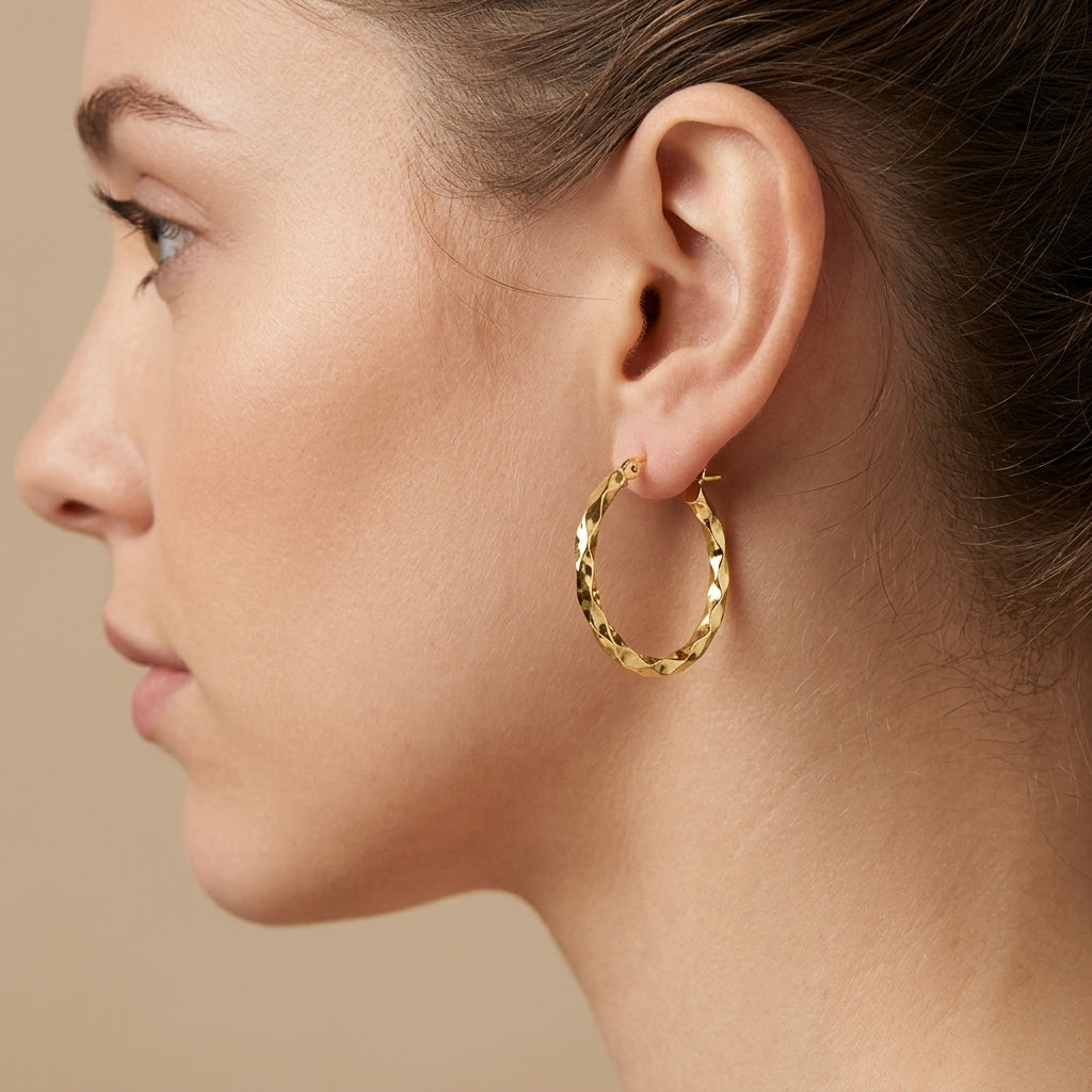 Boucles d'oreilles créoles ciselées en or jaune 18k - bijou porté par une mannequin