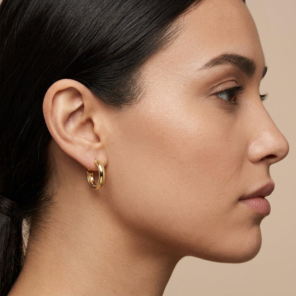 Boucles d'oreilles mini créoles bombées en or jaune 18k - bijou porté par une mannequin