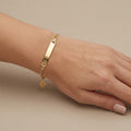 Bracelet chaîne en or jaune 18k plaque à graver - bijou porté par une mannequin