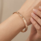 Bracelet jonc en or rose 18k serti de pierres en station - bijou porté par une mannequin