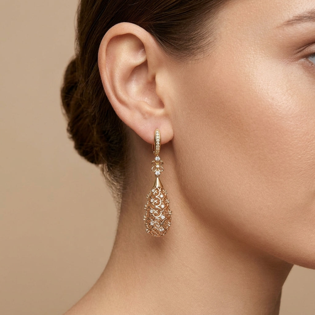 Boucles d'oreilles pendantes gouttes ajourées en or rose 18k serties de pierres - bijou porté par une mannequin