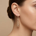 Boucles d'oreilles pendantes gouttes ajourées en or rose 18k serties de pierres - bijou porté par une mannequin