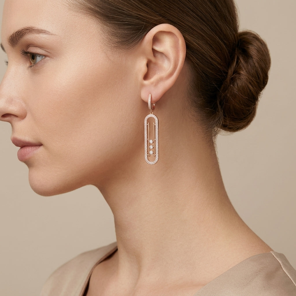 Boucles d'oreilles pendantes en or rose 18k ovales allongés sertis, pierres mobiles - bijou porté par une mannequin