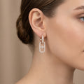 Boucles d'oreilles pendantes maillons en or rose 18k pavés de pierres - bijou porté par une mannequin