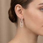 Boucles d'oreilles pendantes maillons en or rose 18k pavés de pierres - bijou porté par une mannequin