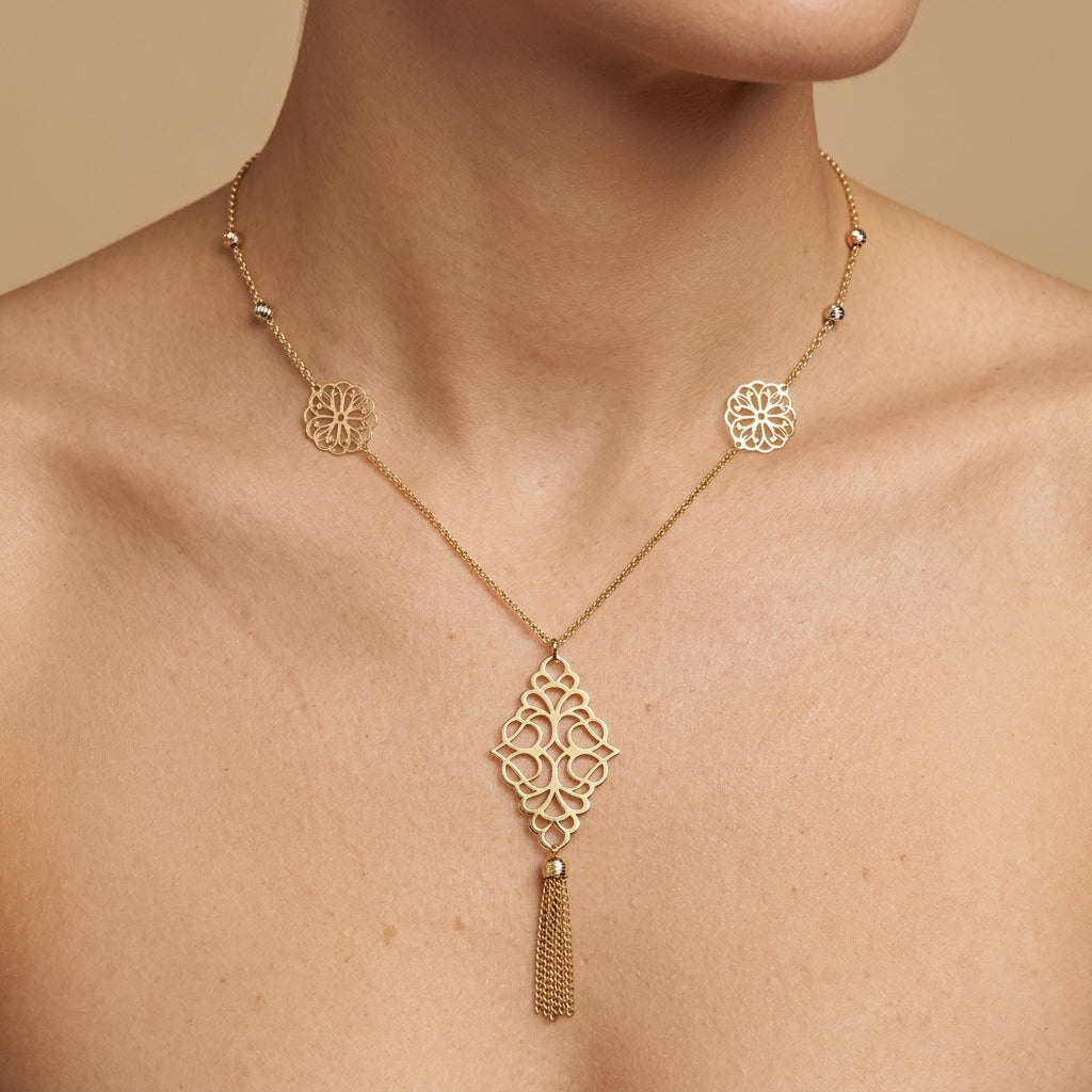 Sautoir en or jaune 18k rosaces en station, pendentif losange à pompon - bijou porté par une mannequin