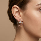 Boucles d'oreilles pendantes couronnes en or rose 18k serties de pierres - bijou porté par une mannequin