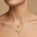 Pendentif fleur quatre pétales en or jaune 18k serti de pierres - bijou porté par une mannequin