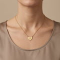 Collier en or jaune 18k pendentif cœur gravé - bijou porté par une mannequin