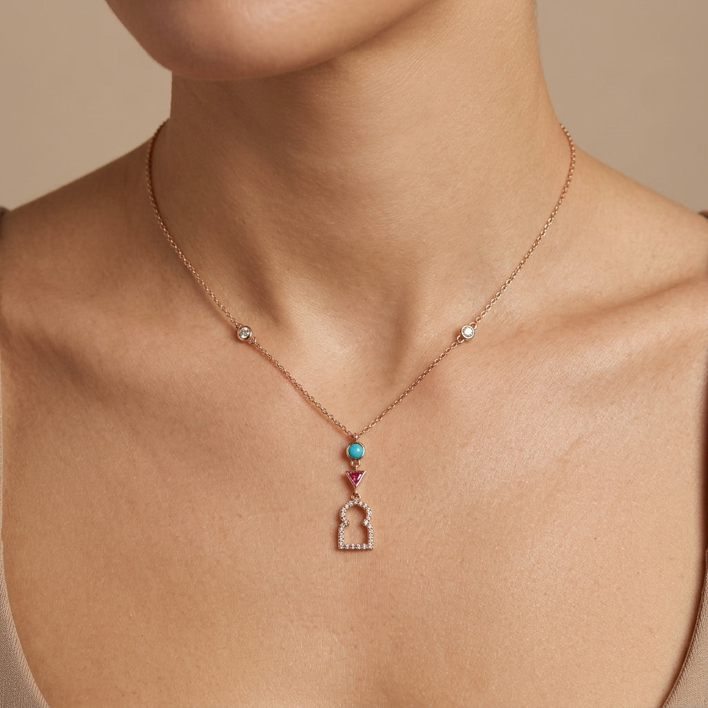 Collier en or rose 18k pendentif porte marocaine sertie, pierres bleue et rouge - bijou porté par une mannequin
