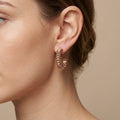 Boucles d'oreilles créoles maille cubaine en or rose 18k - bijou porté par une mannequin